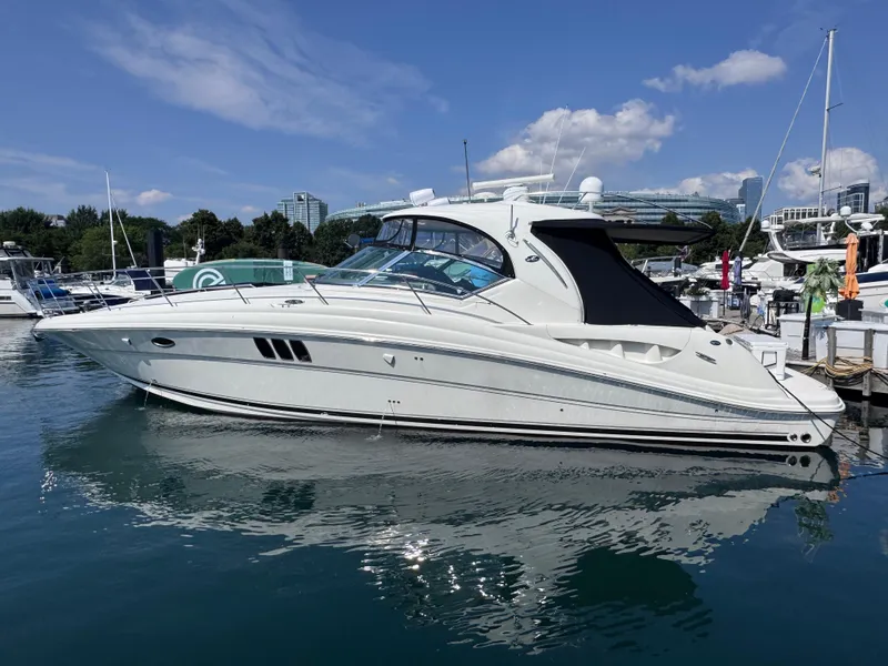 The Image of 2007 Sea Ray 44 Sundancer yacht docked in a marina under a clear blue sky. - 0