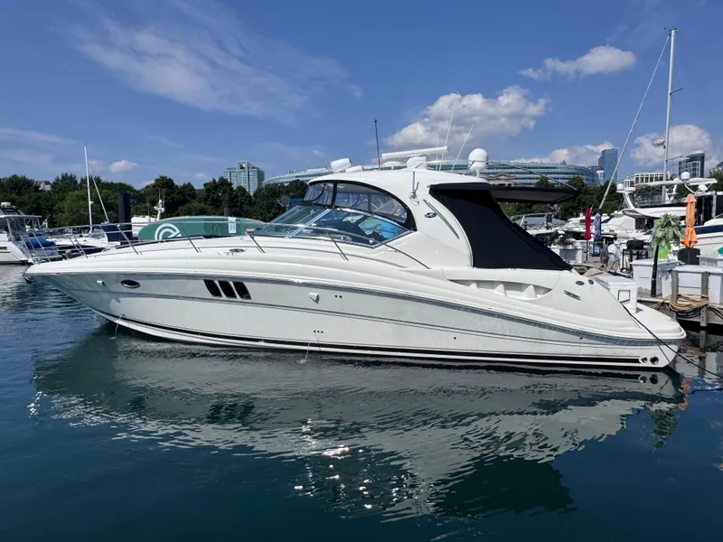 Slide: The Image of 2007 Sea Ray 44 Sundancer yacht docked in a marina under a clear blue sky. - 1