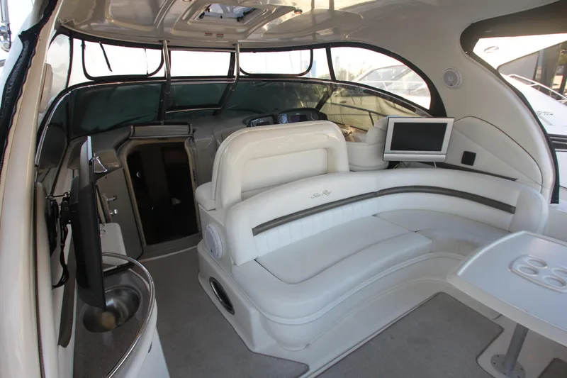 Slide: The Image of 2007 Sea Ray 44 Sundancer interior with white seating, TV, and modern amenities. - 18