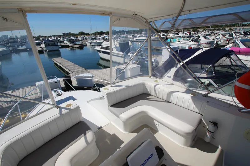 Slide: The Image of 1995 Mainship 31 Sedan Bridge yacht interior at marina, featuring spacious seating and clear views. - 13