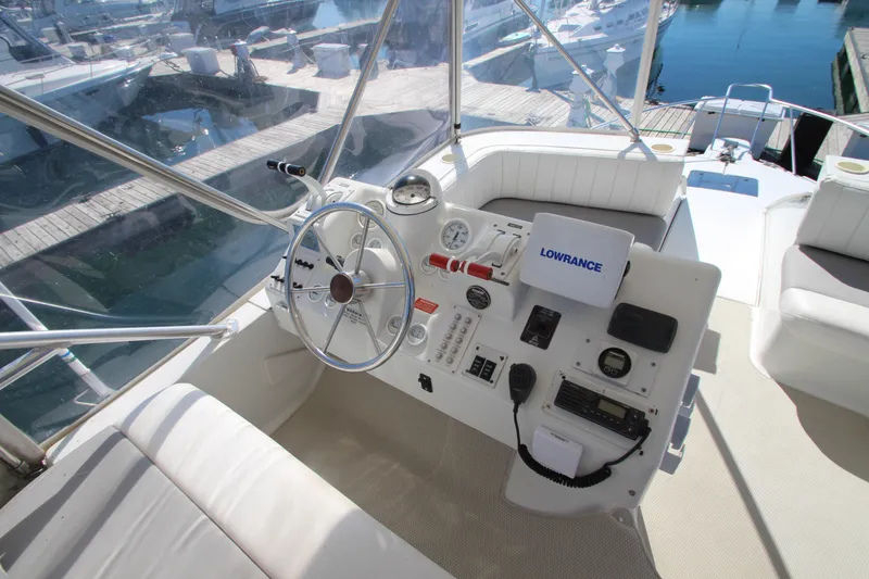 Slide: The Image of 1995 Mainship 31 Sedan Bridge helm with navigation equipment and marina view. - 16