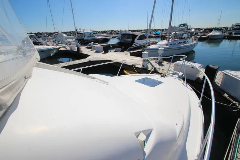 Slide: The Image of 1995 Mainship 31 Sedan Bridge docked at marina, surrounded by other boats. - 24