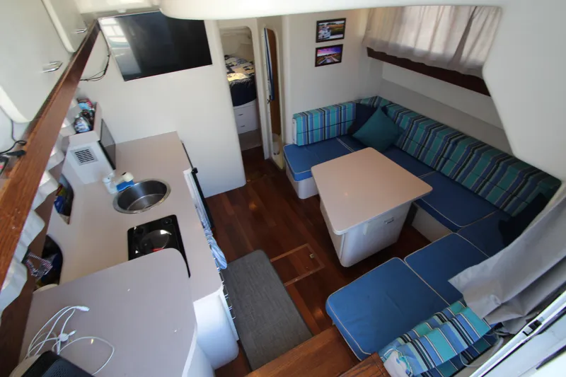 Slide: The Image of Interior of 1995 Mainship 31 Sedan Bridge with cozy seating and kitchenette. - 25