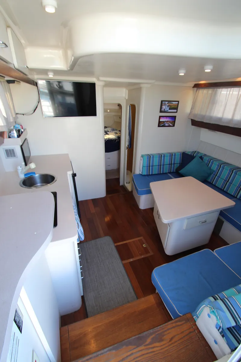 Slide: The Image of 1995 Mainship 31 Sedan Bridge interior with cozy seating and modern amenities. - 26