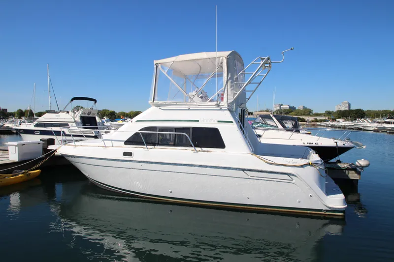 Slide: The Image of 1995 Mainship 31 Sedan Bridge yacht docked in marina under clear blue sky. - 3
