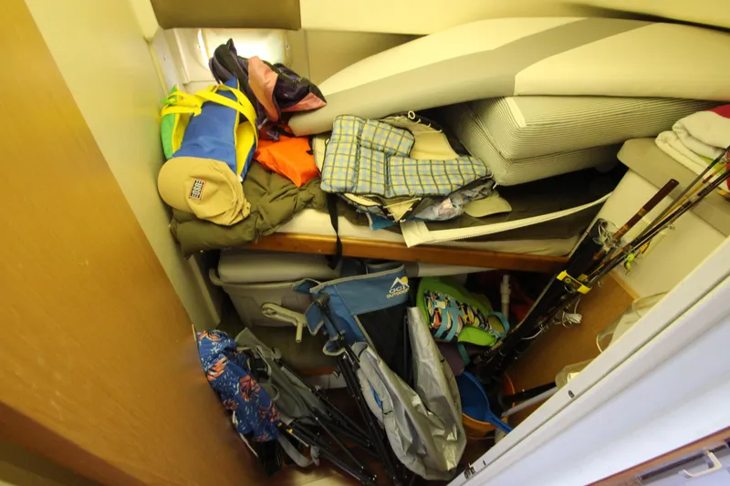 Slide: The Image of Cluttered storage area in 1995 Mainship 31 Sedan Bridge with bags and fishing gear. - 33