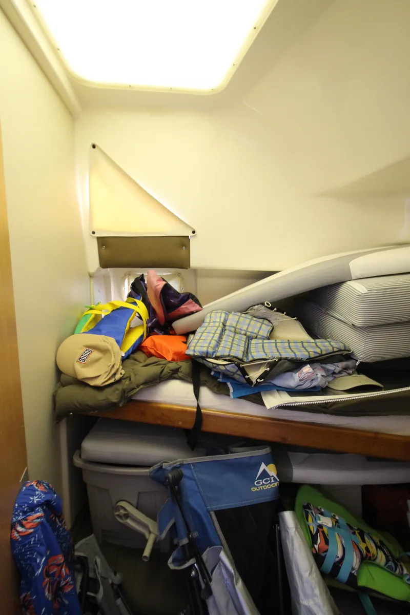 Slide: The Image of Cluttered cabin interior of 1995 Mainship 31 Sedan Bridge with various items and storage. - 34