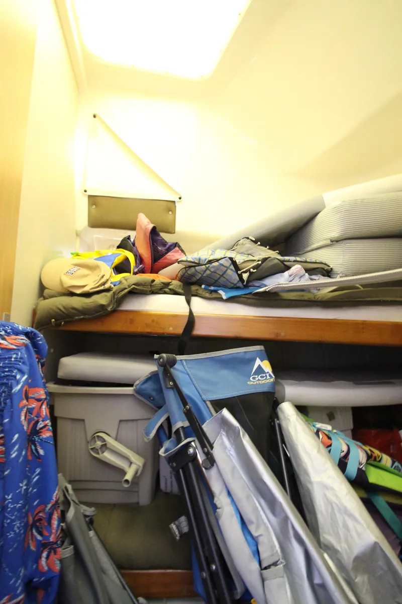 Slide: The Image of 1995 Mainship 31 Sedan Bridge interior storage with camping gear and cushions. - 35