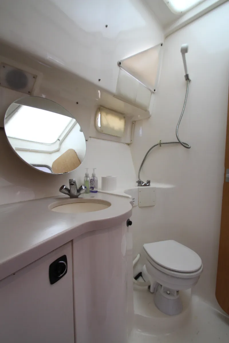 Slide: The Image of Bathroom interior of 1995 Mainship 31 Sedan Bridge yacht, featuring sink and toilet. - 40