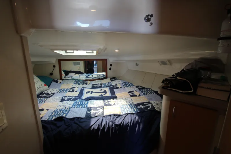 Slide: The Image of 1995 Mainship 31 Sedan Bridge cabin with nautical-themed bedding and cozy interior. - 43
