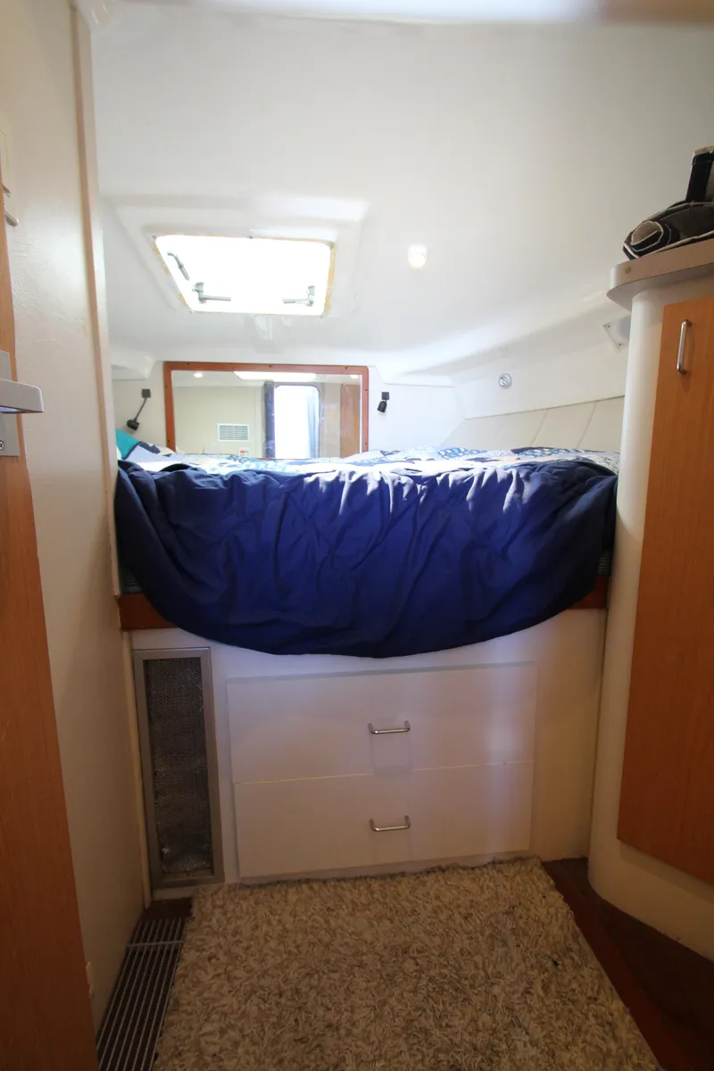 Slide: The Image of 1995 Mainship 31 Sedan Bridge cabin interior with bed and storage drawers. - 44