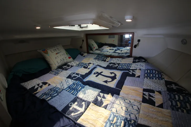 Slide: The Image of Cozy cabin interior of 1995 Mainship 31 Sedan Bridge with nautical-themed bedding. - 45