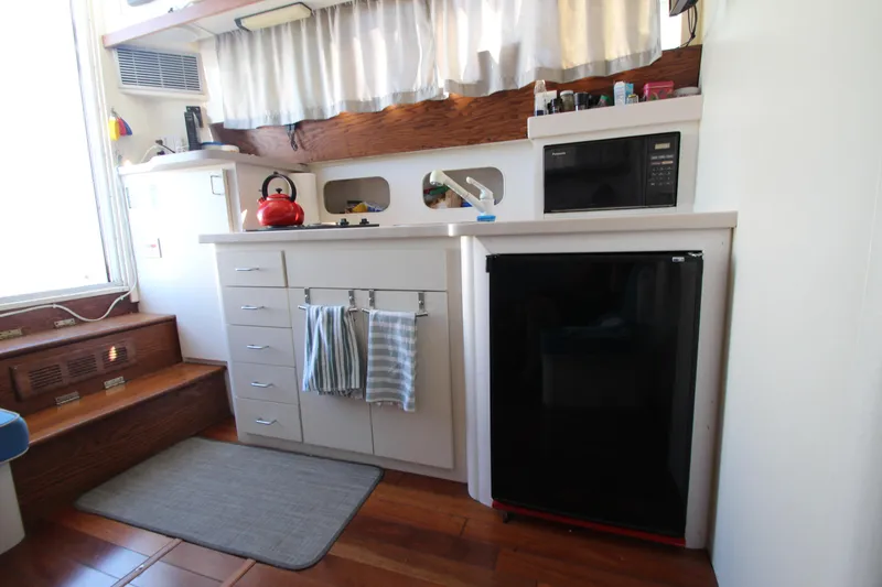 Slide: The Image of 1995 Mainship 31 Sedan Bridge kitchen with fridge, microwave, and kettle. - 48