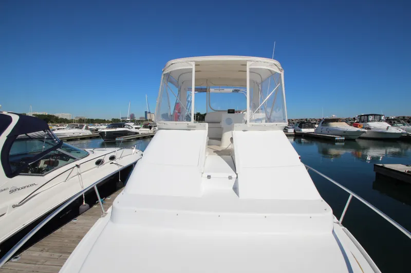 Slide: The Image of 1995 Mainship 31 Sedan Bridge docked in a marina under clear blue skies. - 9