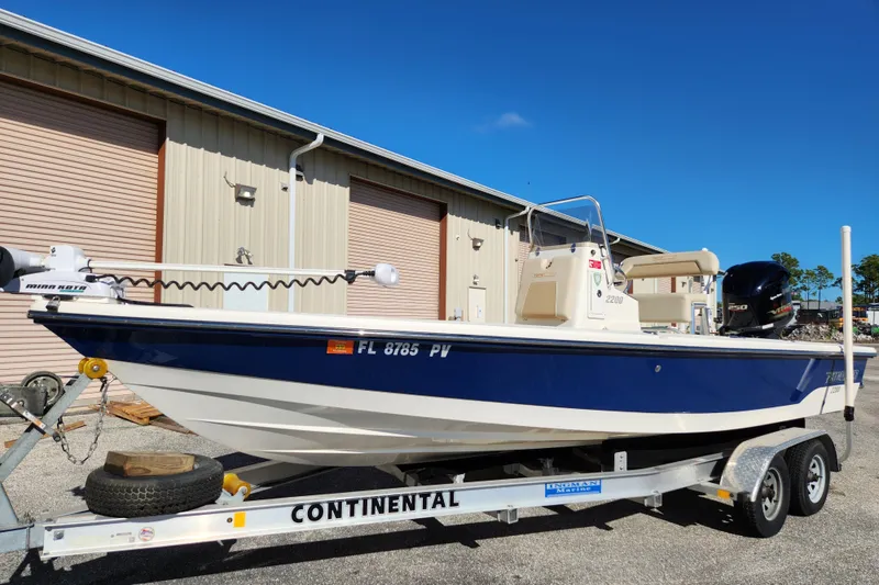 The Image of 2014 Pathfinder 2200 TRS boat on Continental trailer, parked outside a warehouse. - 0