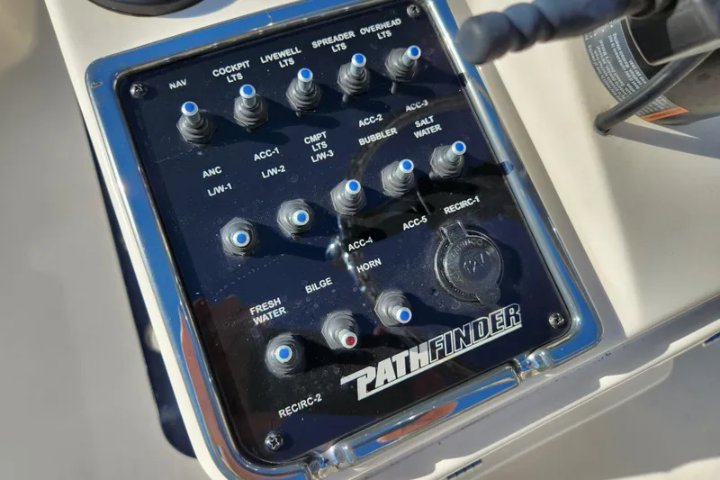 Slide: The Image of Control panel of a 2014 Pathfinder 2200 TRS boat with labeled switches. - 13
