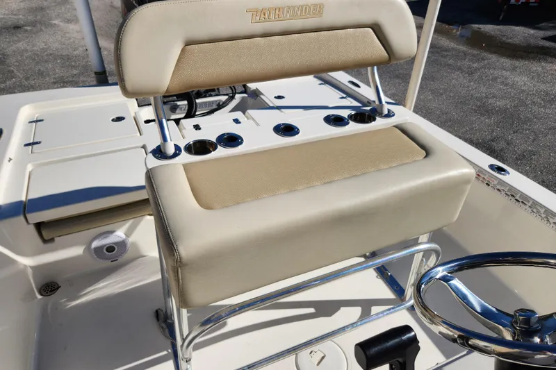 Slide: The Image of 2014 Pathfinder 2200 TRS boat interior with beige seating and steering wheel. - 22