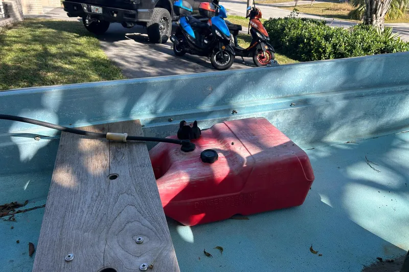 Slide: The Image of 1969 Boston Whaler 13 Sport boat interior with red fuel tank and wooden seat. - 10