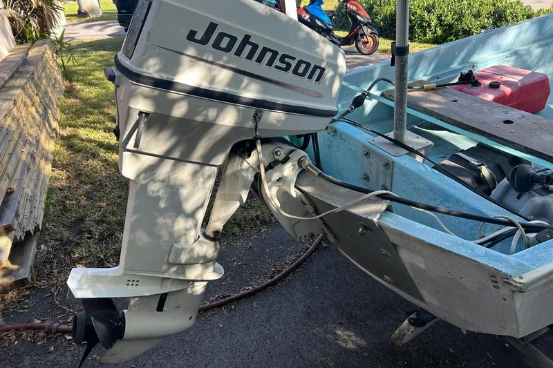 Slide: The Image of 1969 Boston Whaler 13 Sport with Johnson outboard motor, parked on a driveway. - 12
