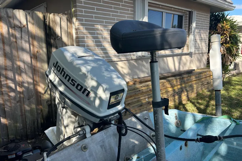 Slide: The Image of 1969 Boston Whaler 13 Sport with Johnson outboard motor, parked near a house. - 7