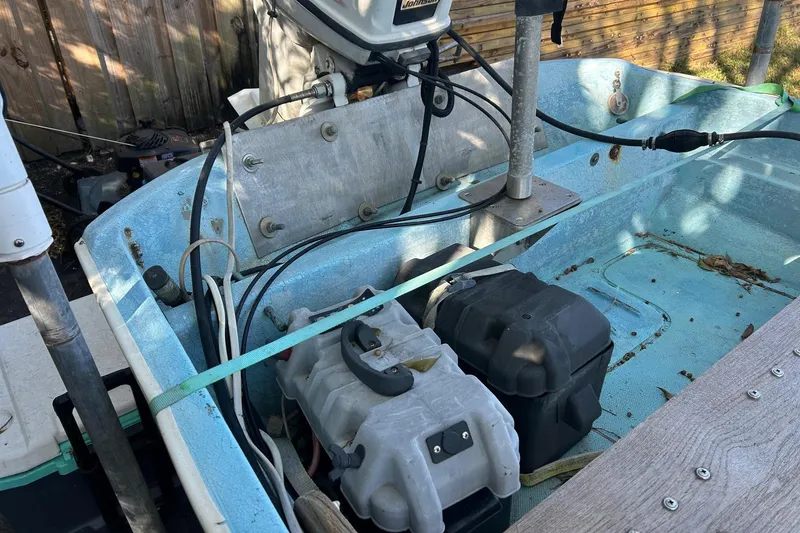 Slide: The Image of 1969 Boston Whaler 13 Sport boat interior with motor and equipment, showing wear and age. - 8