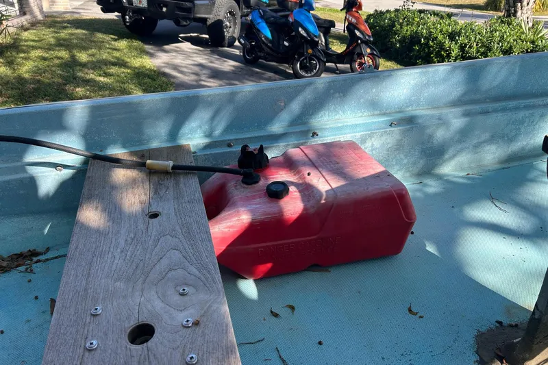 Slide: The Image of 1969 Boston Whaler 13 Sport boat interior with red fuel tank and wooden seat. - 9