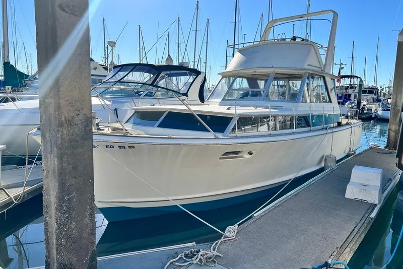 The Image of 1967 Chris-Craft 38 Constellation yacht docked in a marina under clear blue skies. - 0