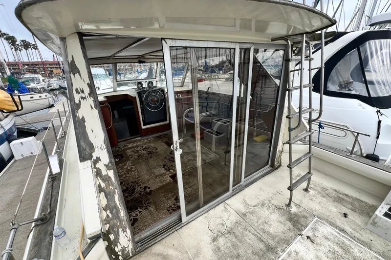 Slide: The Image of 1967 Chris-Craft 38 Constellation yacht with weathered exterior and marina view. - 13