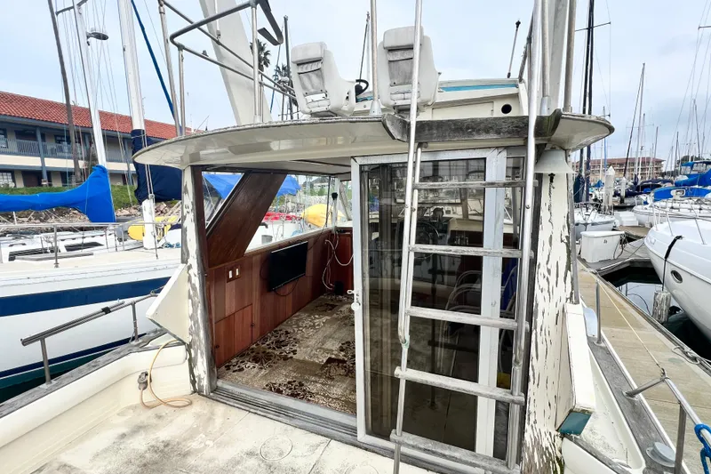 Slide: The Image of 1967 Chris-Craft 38 Constellation yacht with weathered exterior, docked at marina. - 14