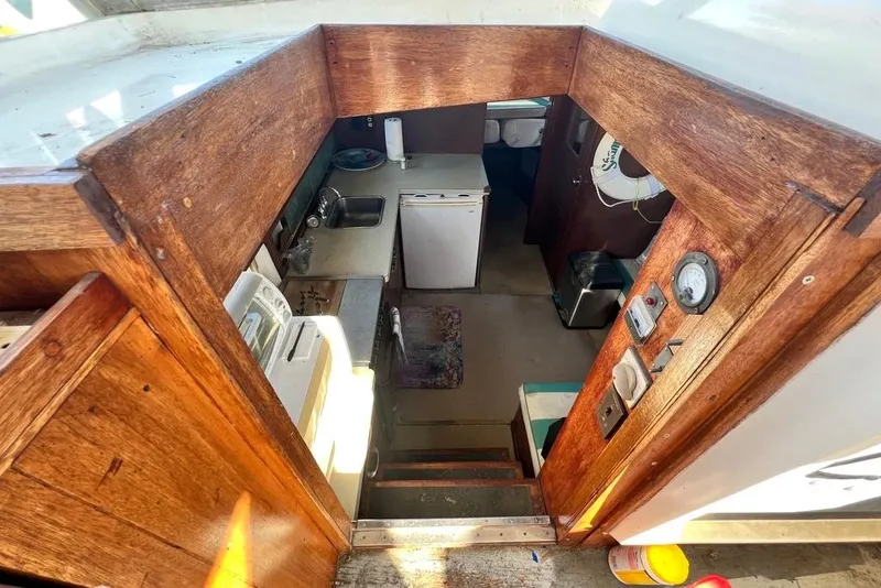 Slide: The Image of Interior view of 1967 Chris-Craft 38 Constellation boat, featuring wooden cabinetry and compact kitchen area. - 19