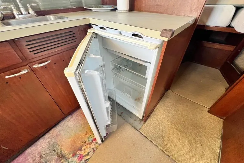 Slide: The Image of 1967 Chris-Craft 38 Constellation kitchen with open fridge and wooden cabinetry. - 27