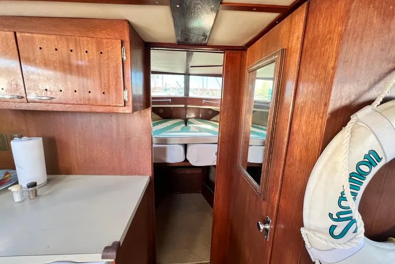 Slide: The Image of Interior of 1967 Chris-Craft 38 Constellation boat with wooden cabinetry and cozy sleeping area. - 28
