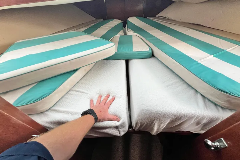 Slide: The Image of Interior of 1967 Chris-Craft 38 Constellation with striped cushions and hand on bed. - 31