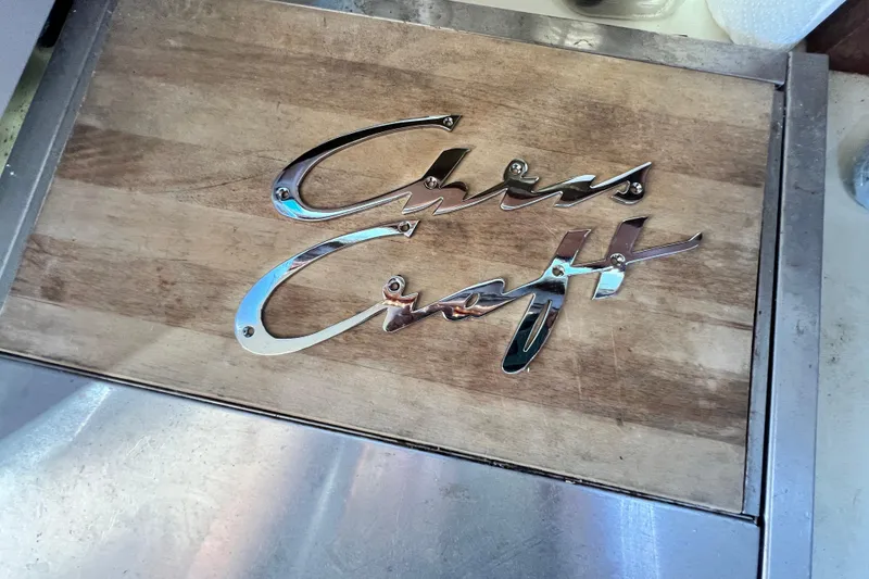 Slide: The Image of Chris-Craft 38 Constellation 1967 logo on wooden surface, showcasing vintage boat branding. - 36