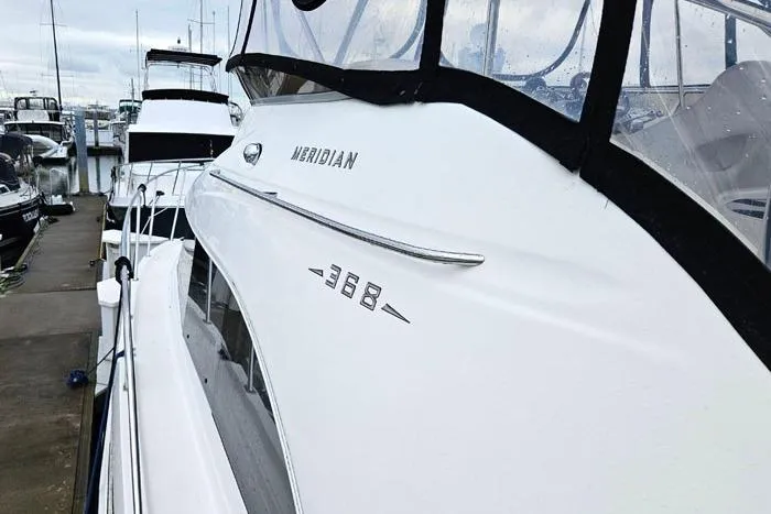 Slide: The Image of 2006 Meridian 368 Motoryacht docked at marina, showcasing sleek design and branding. - 6