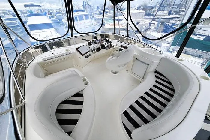 Slide: The Image of 2006 Meridian 368 Motoryacht helm with panoramic marina view, featuring sleek white seating. - 7