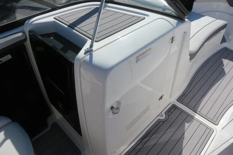 Slide: The Image of 2017 Yamaha Boats AR240 storage compartments with open lids, showcasing interior space. - 23