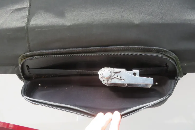 Slide: The Image of Zippered compartment on 2017 Yamaha AR240 boat, revealing a metal mechanism inside. - 70