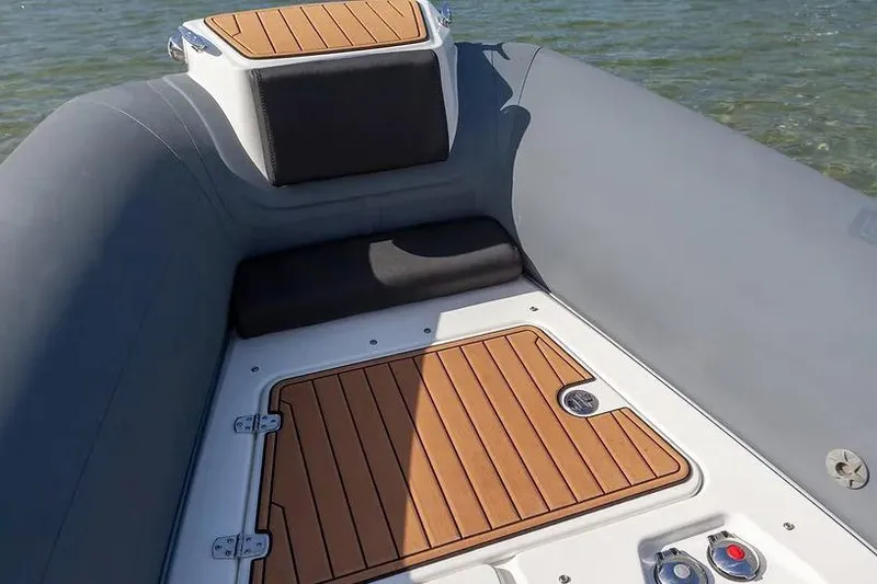Slide: The Image of Manufacturer Provided Image: 2026 Brig Eagle 8 boat interior with teak flooring and cushioned seating. - 2