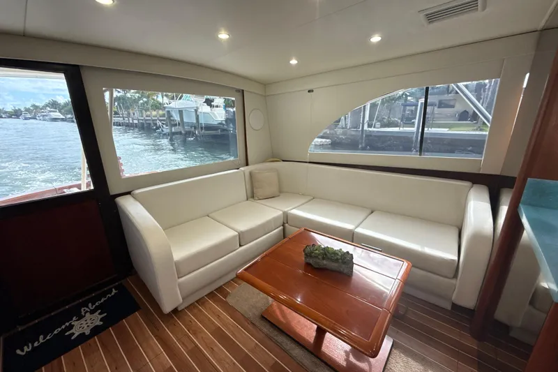 Slide: The Image of Luxurious interior of 1992 Ocean Yachts 48 Super Sport with white seating and wooden table. - 11