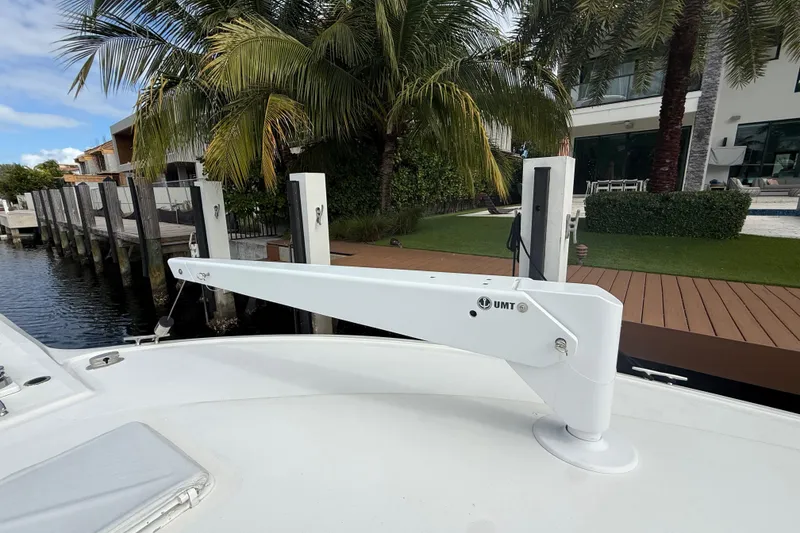 Slide: The Image of 1992 Ocean Yachts 48 Super Sport docked, featuring a UMT davit arm, surrounded by lush greenery. - 40