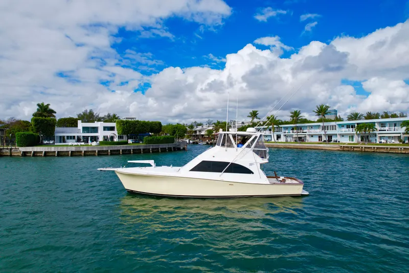 The Image of 1992 Ocean Yachts 48 Super Sport cruising on a scenic waterway with palm trees. - 0