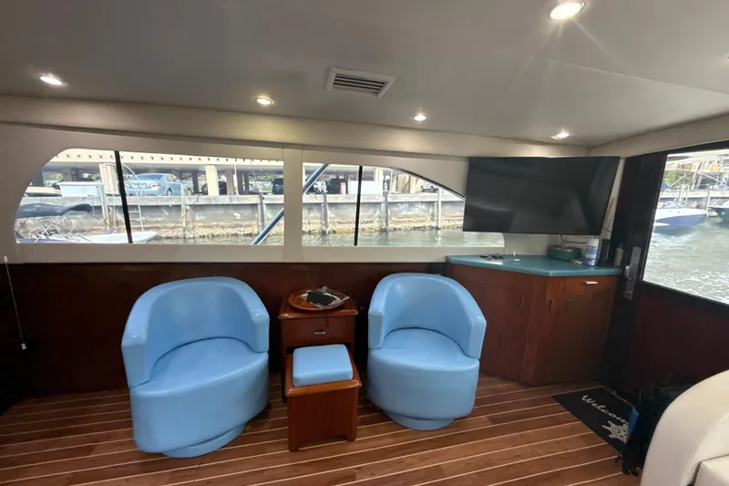 Slide: The Image of Interior of 1992 Ocean Yachts 48 Super Sport with blue chairs and a mounted TV. - 12