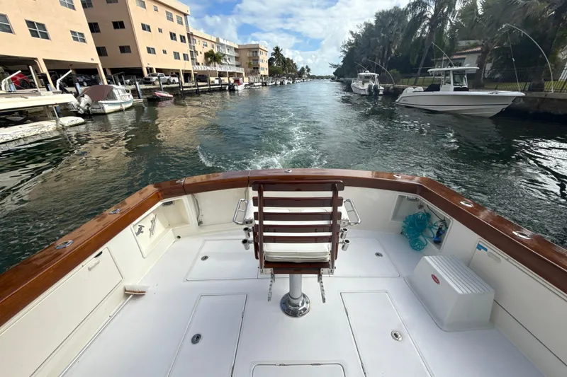 Slide: The Image of 1992 Ocean Yachts 48 Super Sport boat cruising through a canal with docked boats. - 5