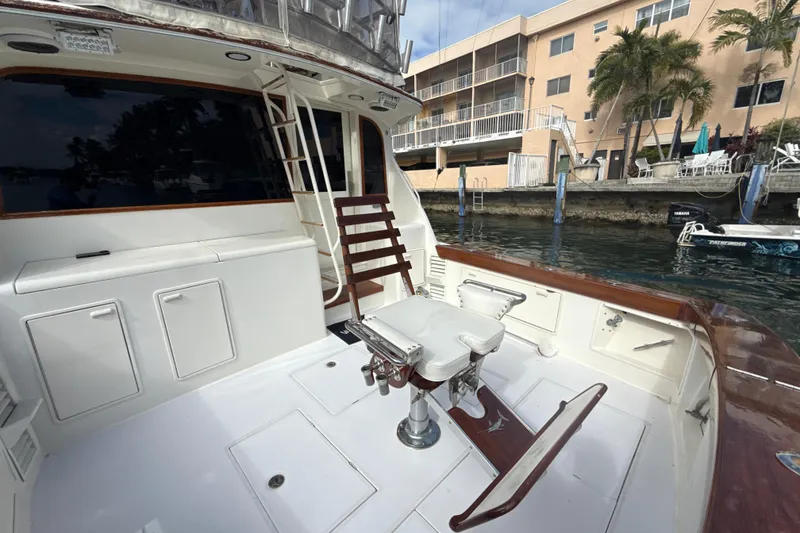 Slide: The Image of 1992 Ocean Yachts 48 Super Sport fishing deck with chair, docked near waterfront buildings. - 6