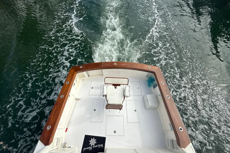Slide: The Image of 1992 Ocean Yachts 48 Super Sport cruising, view from deck, wooden railings, water wake visible. - 9