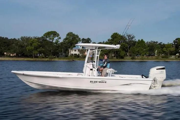 The Image of 2018 Blue Wave 2400 PureBay boat on trailer, parked in driveway under clear sky. - 0