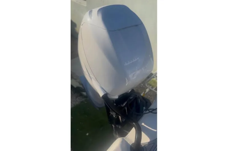 Slide: The Image of 2018 Blue Wave 2400 PureBay boat on trailer, featuring a powerful outboard motor. - 2