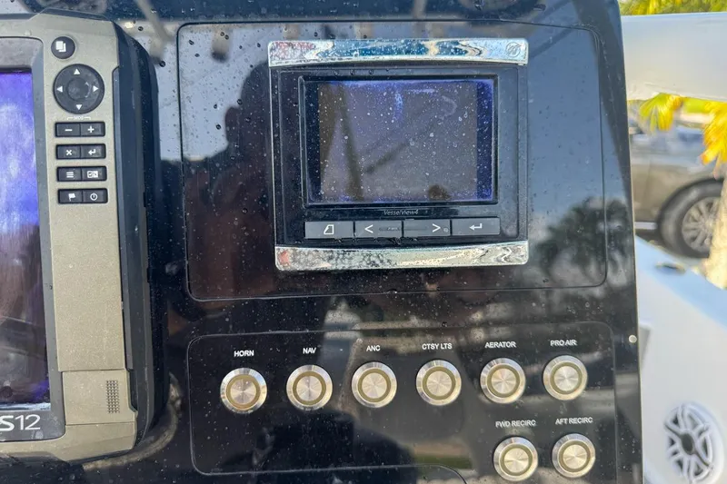 Slide: The Image of Control panel of a 2018 Blue Wave 2400 PureBay boat with various buttons and screens. - 46