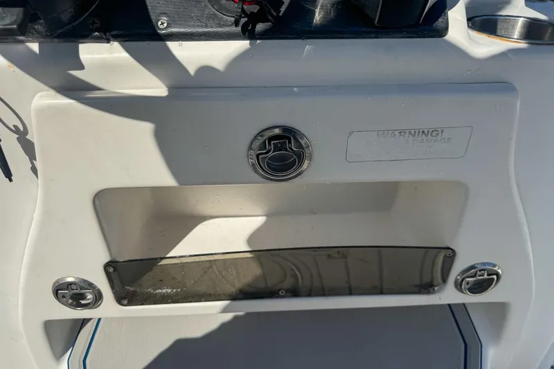 Slide: The Image of 2018 Blue Wave 2400 PureBay boat dashboard with storage compartment and warning label. - 47